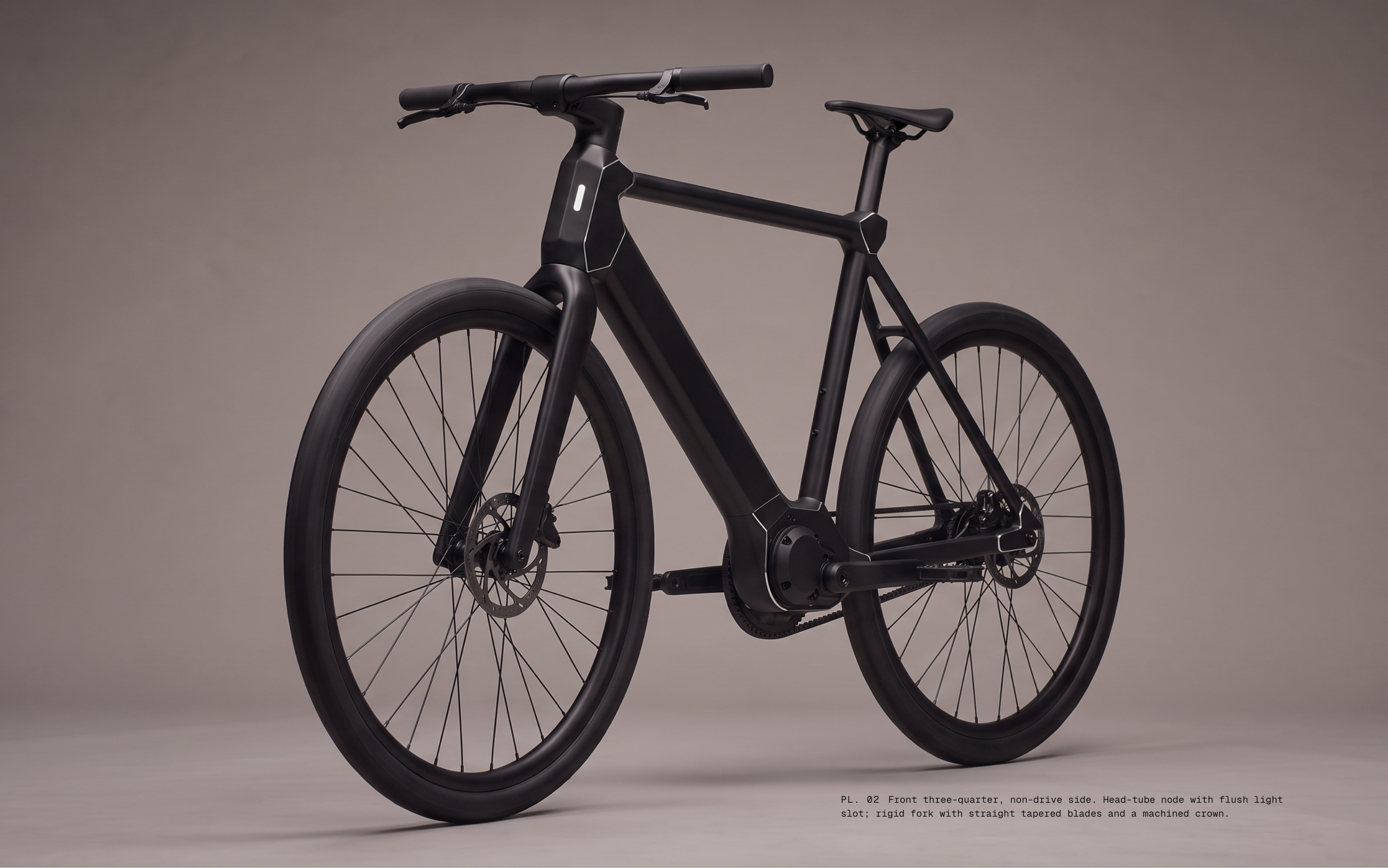 PL. 02 Front three-quarter, non-drive side. Head-tube node with flush light slot; rigid fork with straight tapered blades and a machined crown.